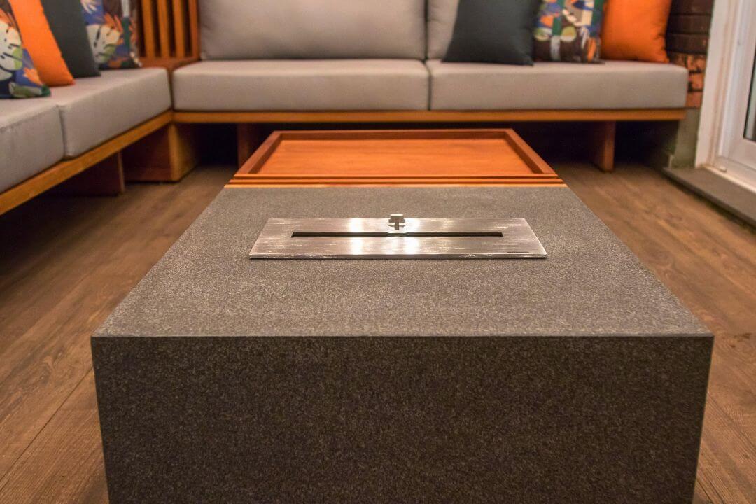 Varanda gourmet com lareira ecológica Somer integrada ao mobiliário.