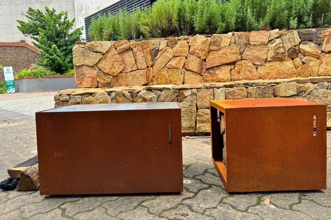 Sala de estar com lareira ecológica Somer instalada em nicho de pedra.