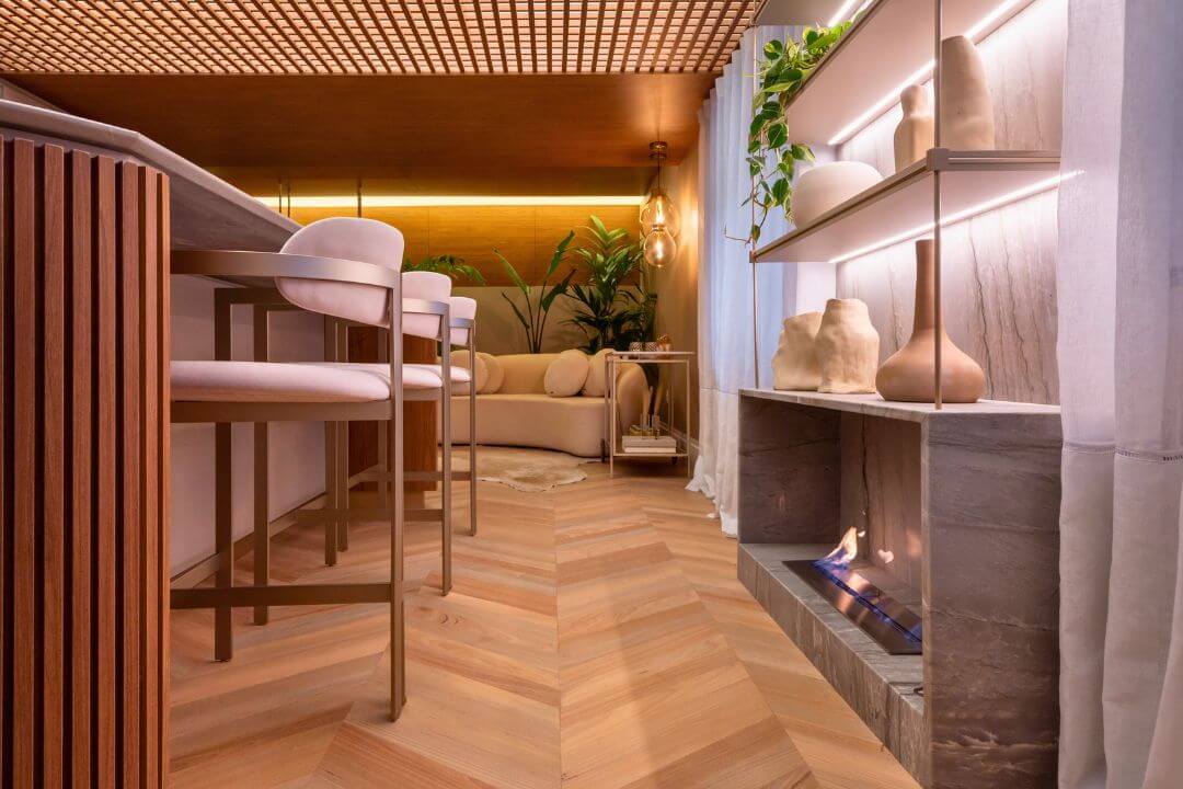 Sala de estar com lareira ecológica Somer instalada em nicho de pedra.