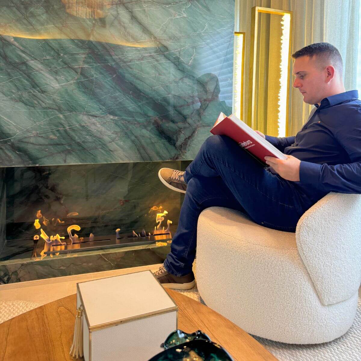 Sala de estar com lareira ecológica Somer instalada em nicho de pedra.