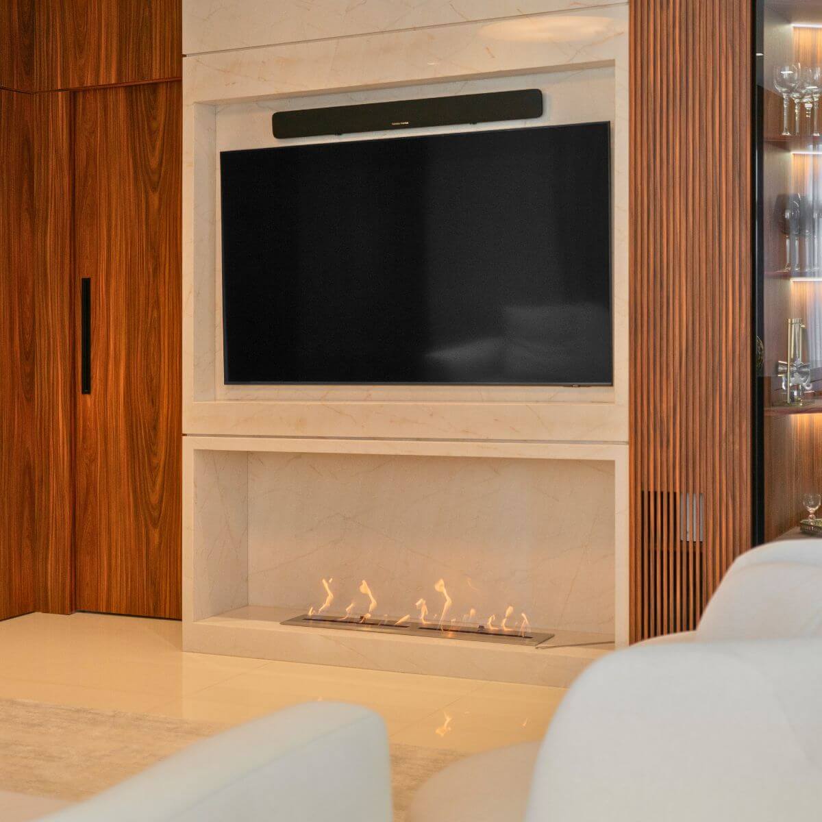 Varanda gourmet com lareira ecológica Somer integrada ao mobiliário.