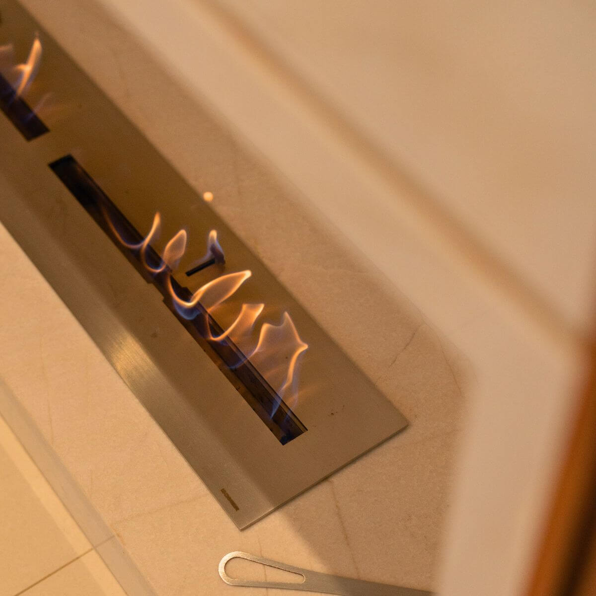 Varanda gourmet com lareira ecológica Somer integrada ao mobiliário.