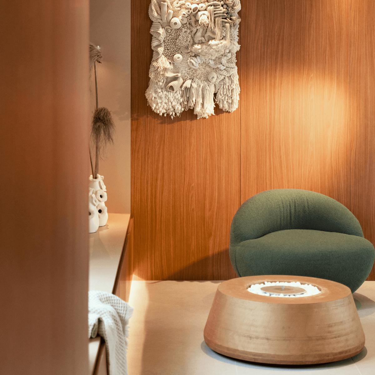 Sala de estar com lareira ecológica Somer instalada em nicho de pedra.